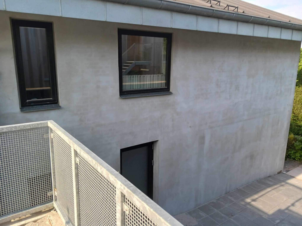 Moderne bygning med altan og grå facade